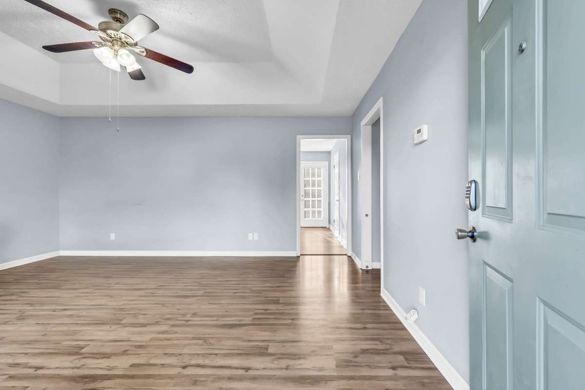 Entry way leads to open living area with trey ceiling for added height- Wood floors