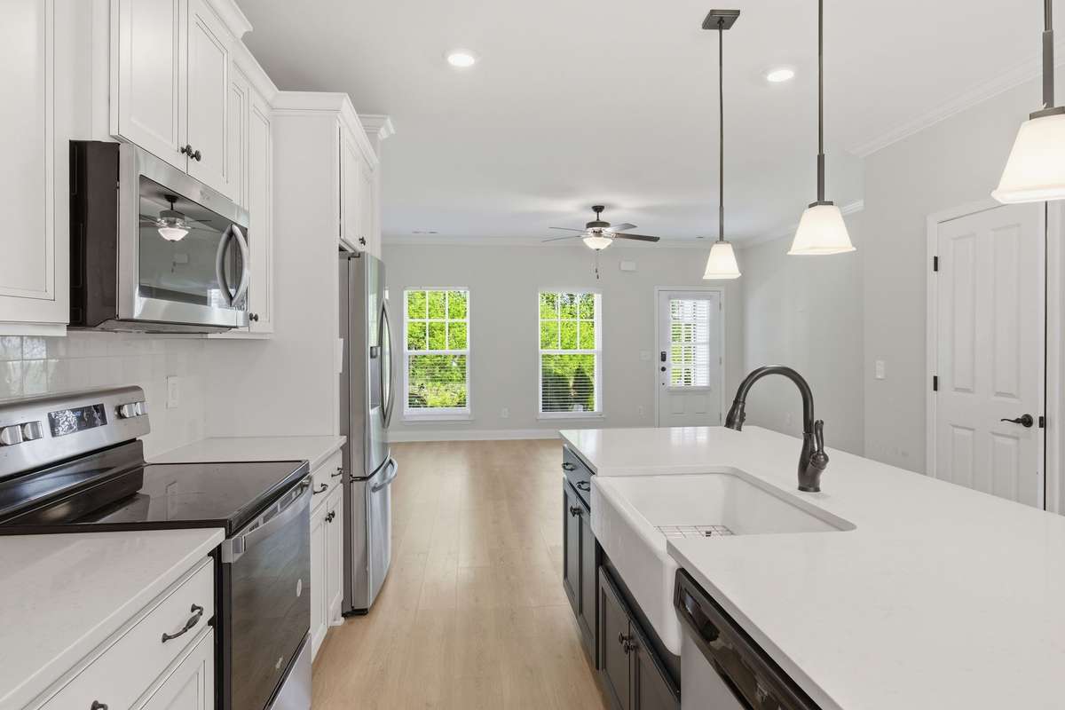 Kitchen with pantry and upgraded finishes. Stainless-steel refrigerator stays with the home.