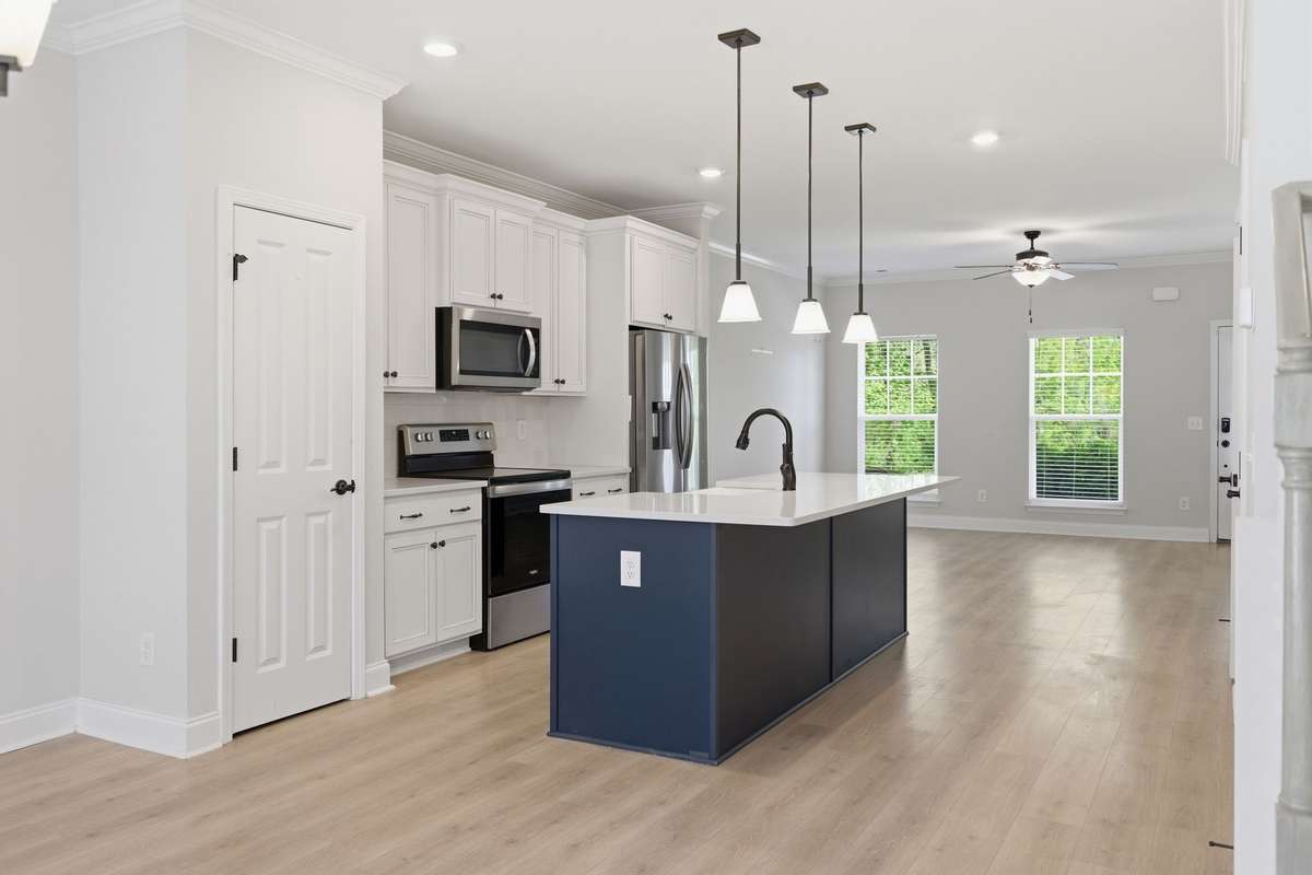 Kitchen with pantry and upgraded finishes. Stainless-steel refrigerator stays with the home.
