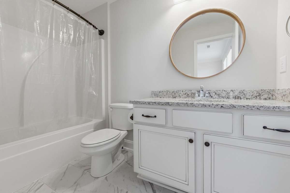 Secondary bathroom with full-size tub and shower combo.