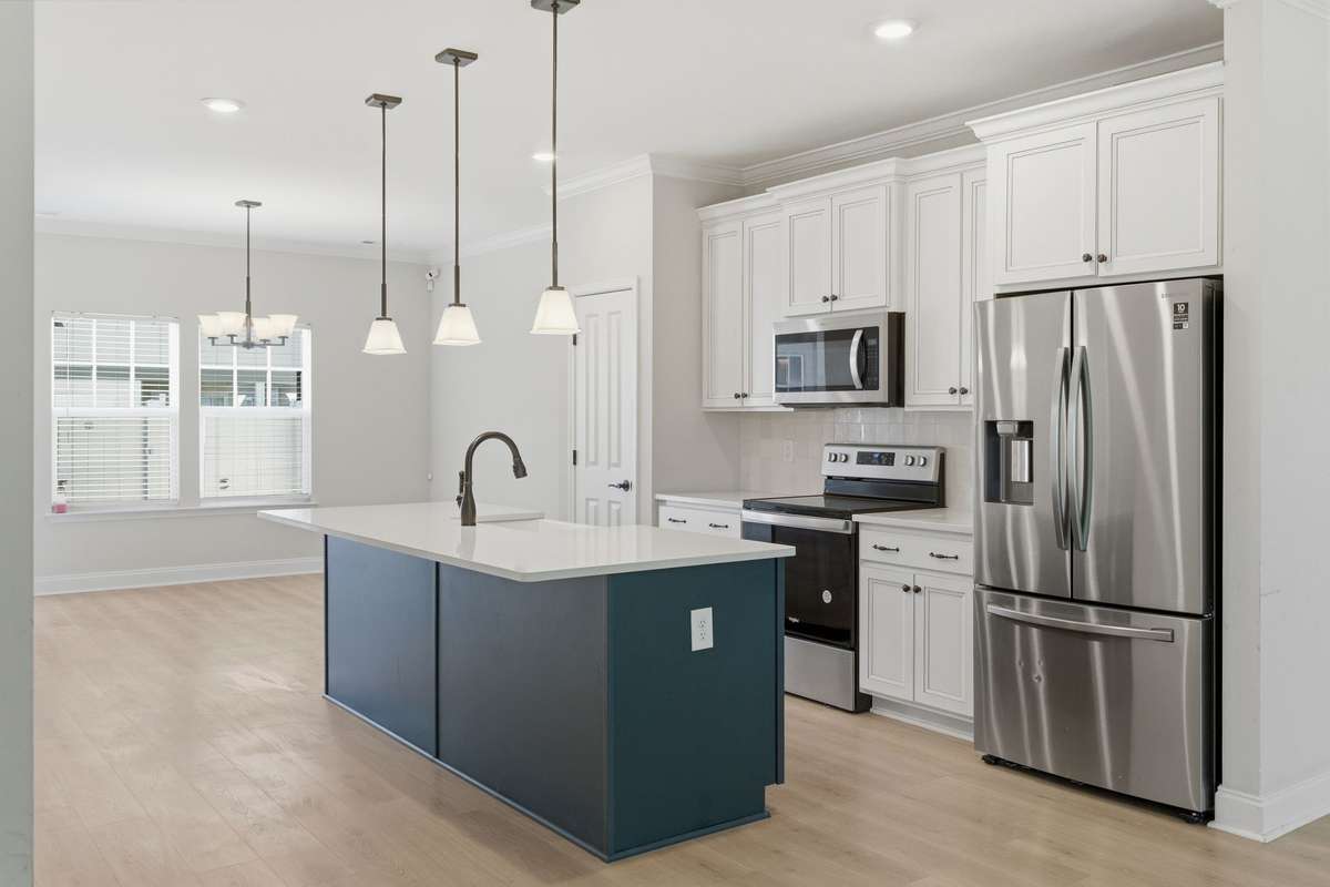 Kitchen with pantry and upgraded finishes. Stainless-steel refrigerator stays with the home.