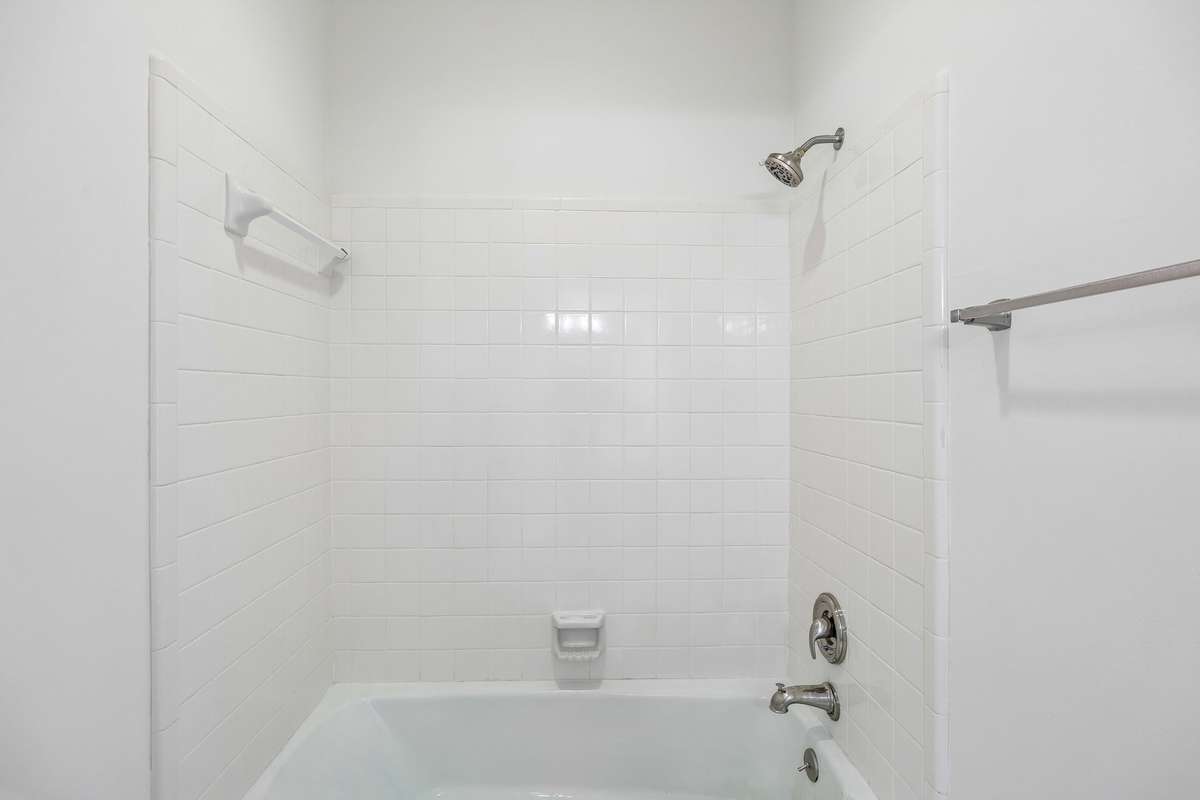 Tub/shower combination in bath adjoining secondary bedroom.