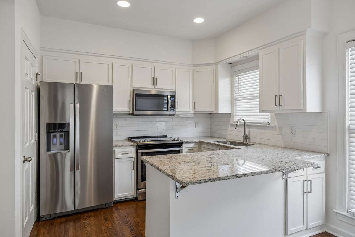Updated kitchen with new refrigerator, stove, microwave and dishwasher.   Large pantry door to the left of the refrigerator.