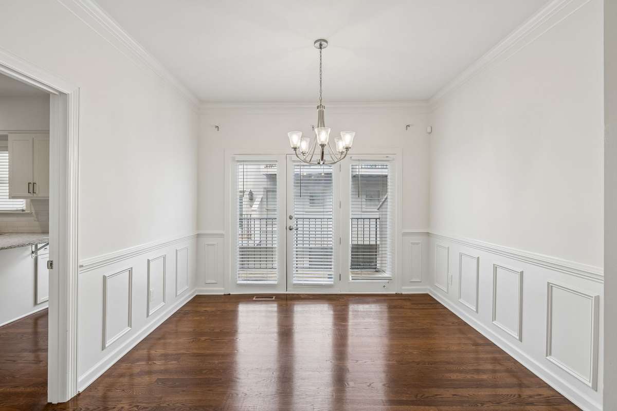 This large dining room features wainscotting trim.  Step out to your balcony from dining room door.   Lots of light flows from this dining room to the family room space!