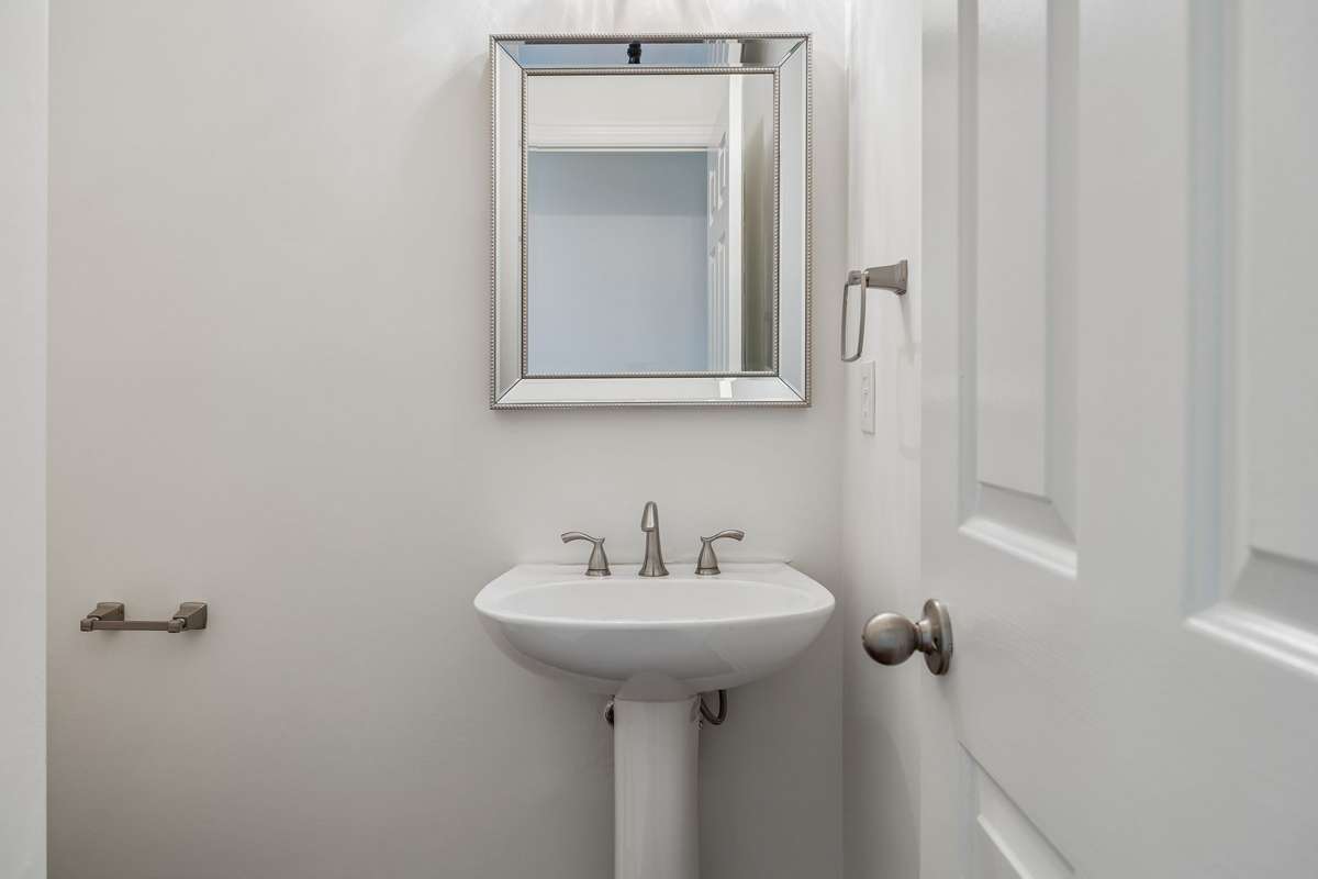 Powder room on main floor with toilet to the left of sink.