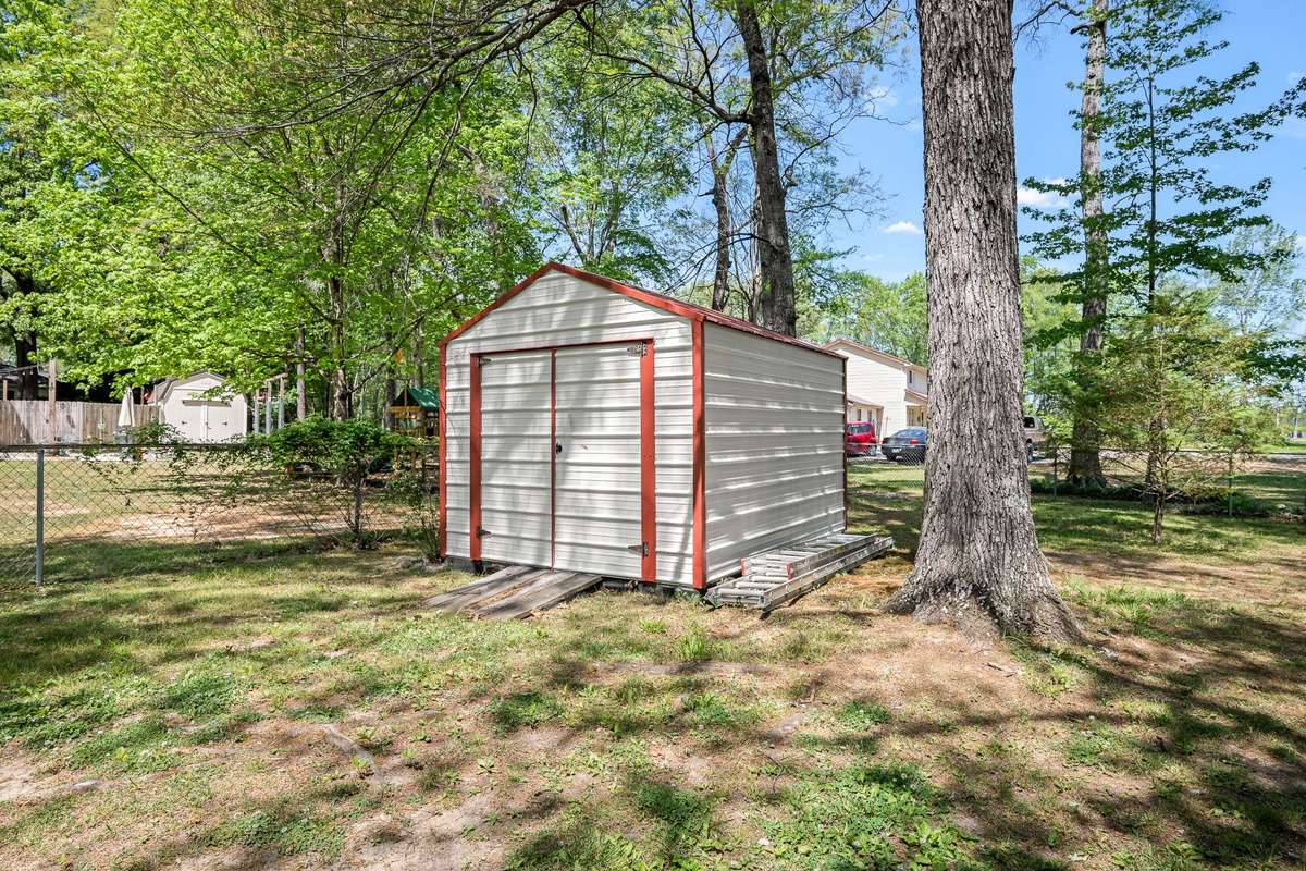 Storage building in fenced back yard.