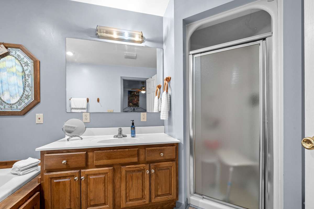 Primary bath has walk-in shower and vanity.