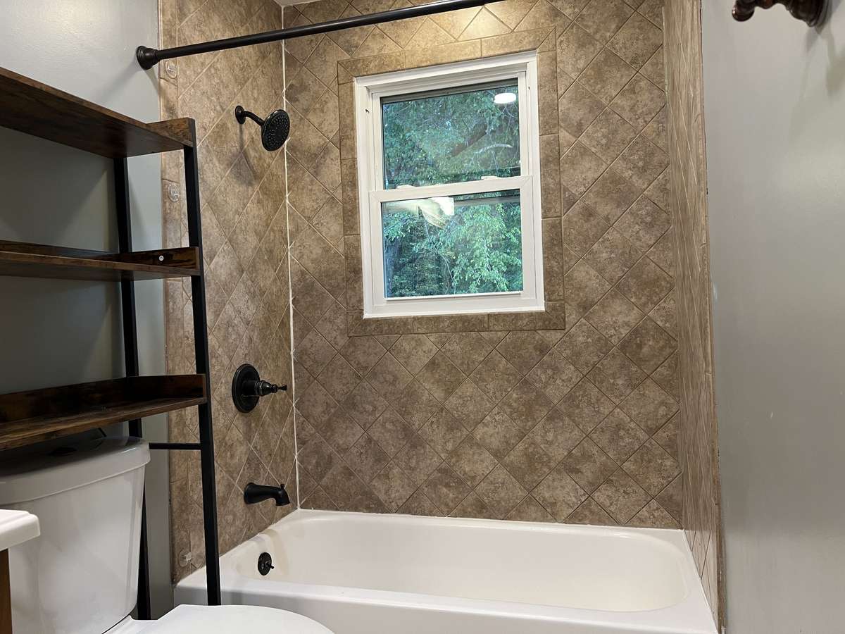 Full Bath: The tiled shower showcasing a window into the lush green outdoors will make getting ready seem like a vacation. (No need to worry about people seeing in the window. There's acres of land between you and anyone else.)