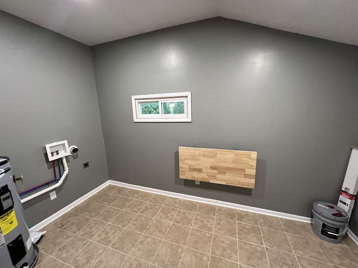 This mud/utility room has a fold up table and a fold down ironingboard to make laundry day a breeze!
