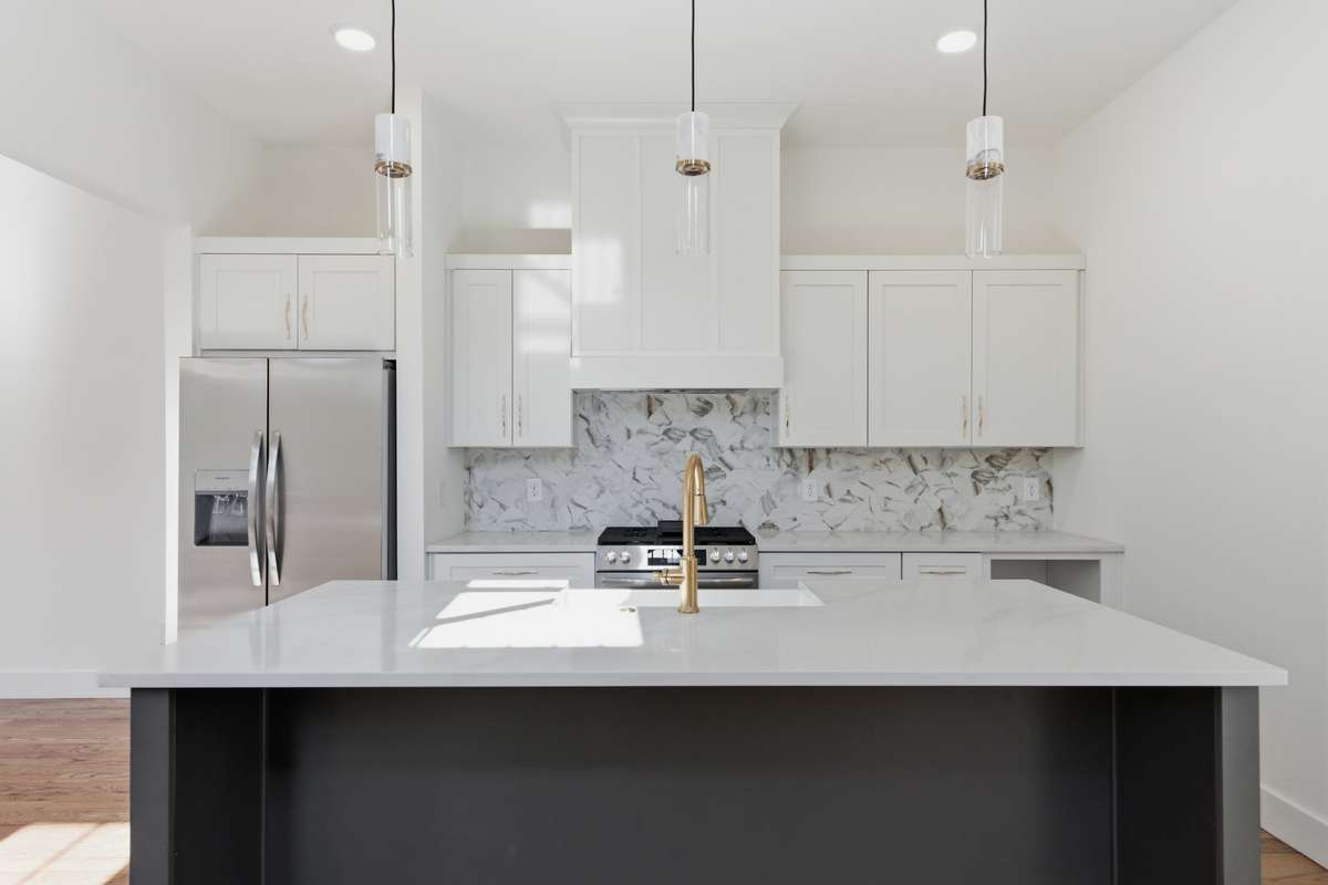 White shaker cabinets provide tons of storage and pair perfectly with the clean, durable quartz countertops.
