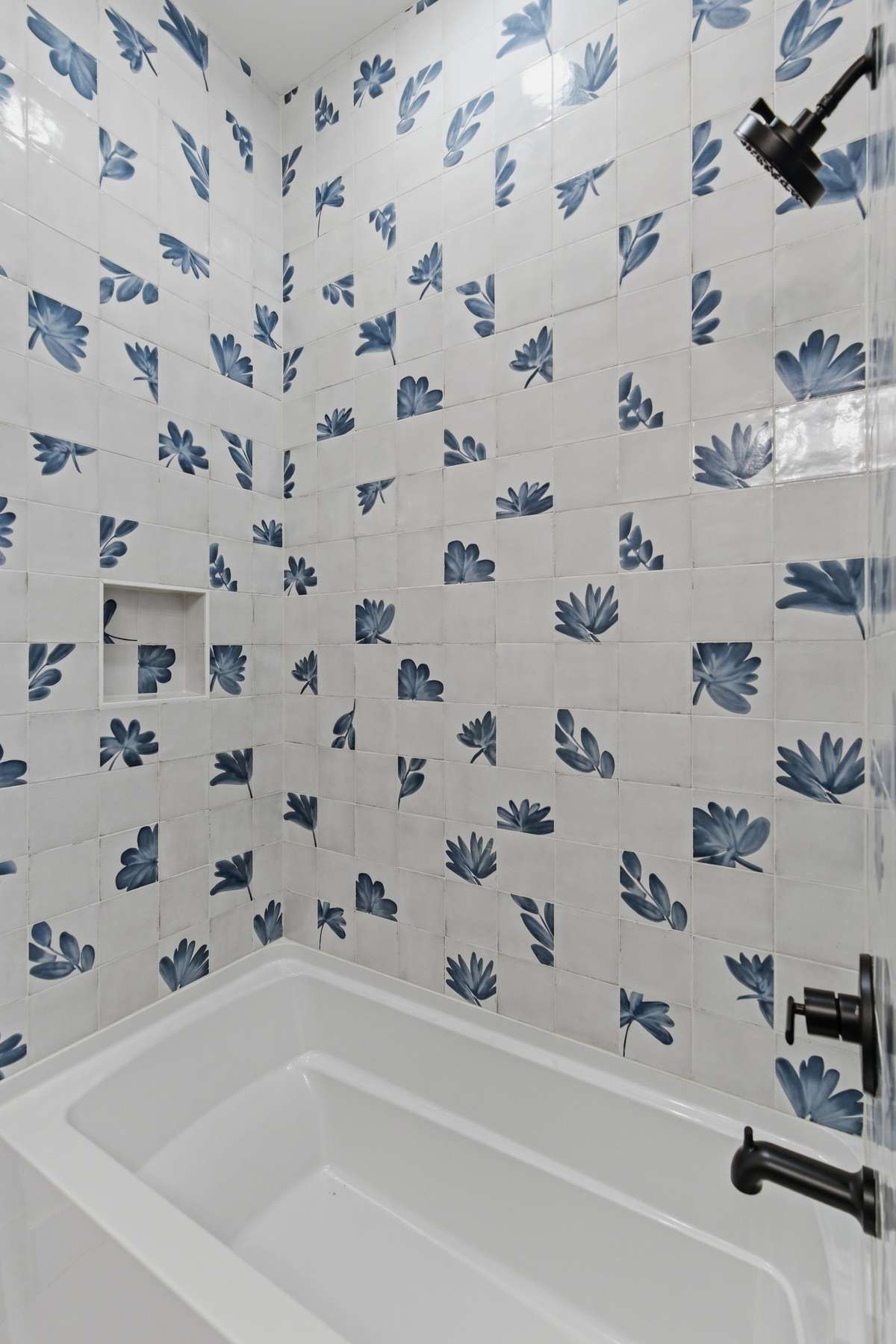 Beautiful full-height designer tile and deep soaking tub give the guest bathroom a high-end, custom look.