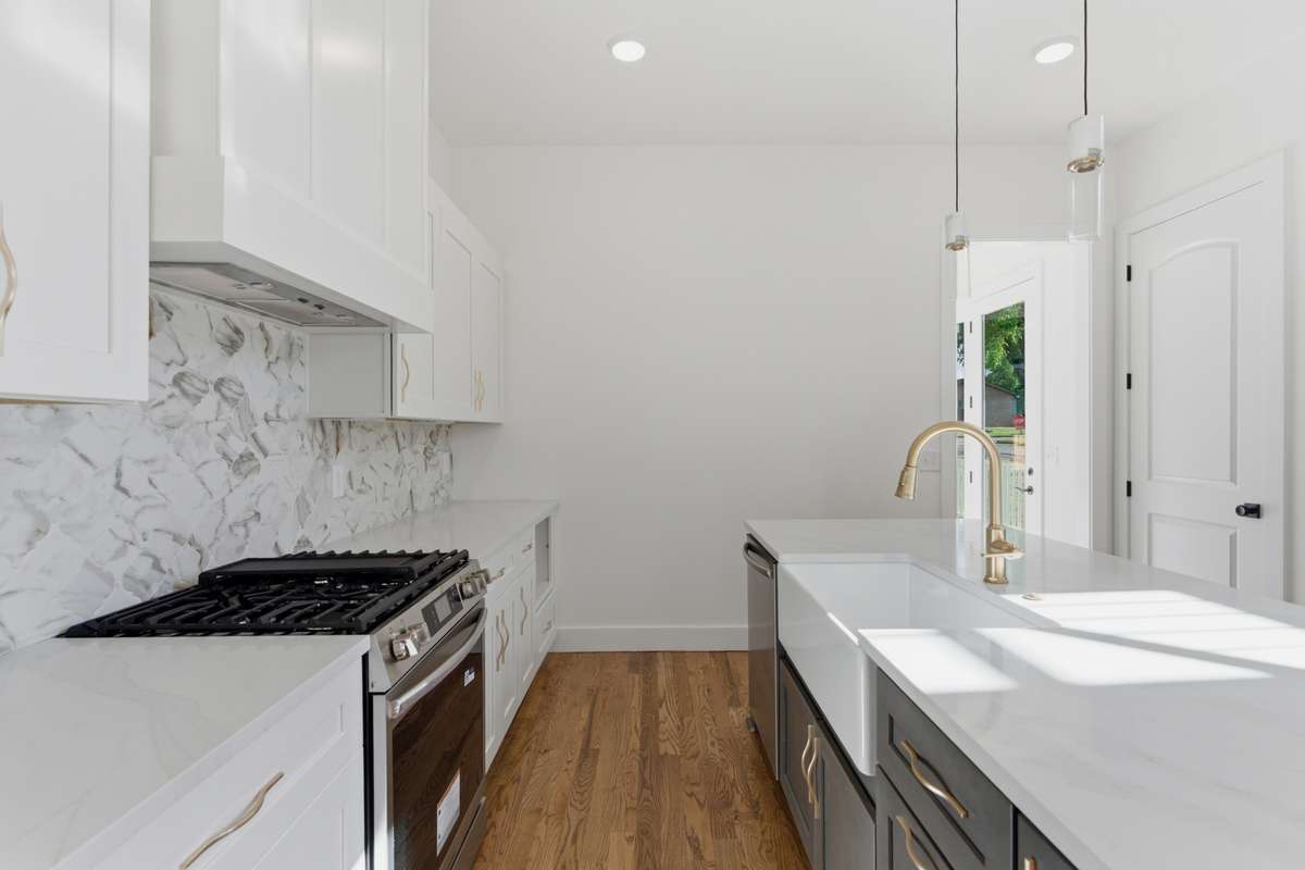 The deep white farmhouse sink and gooseneck faucet make the island both a functional workspace and a design centerpiece.
