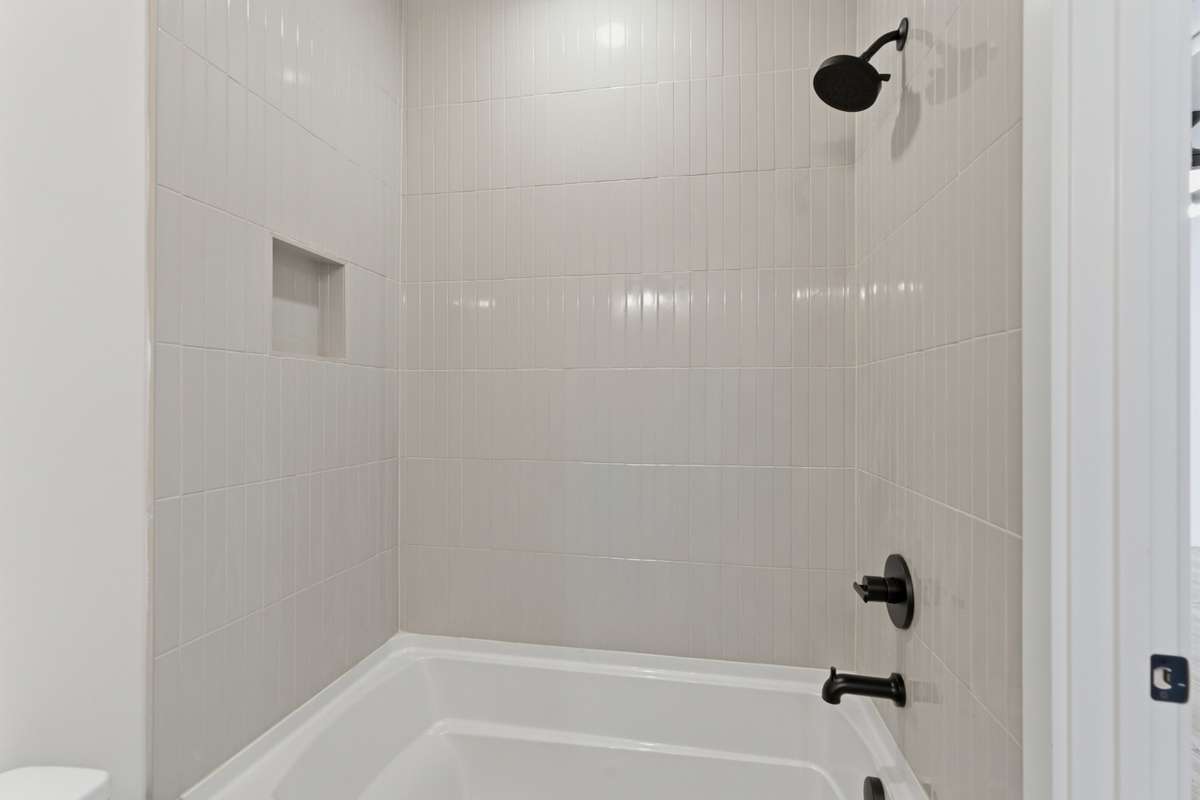 A full tub with floor-to-ceiling vertical stack tile provides a modern and polished look to the space.