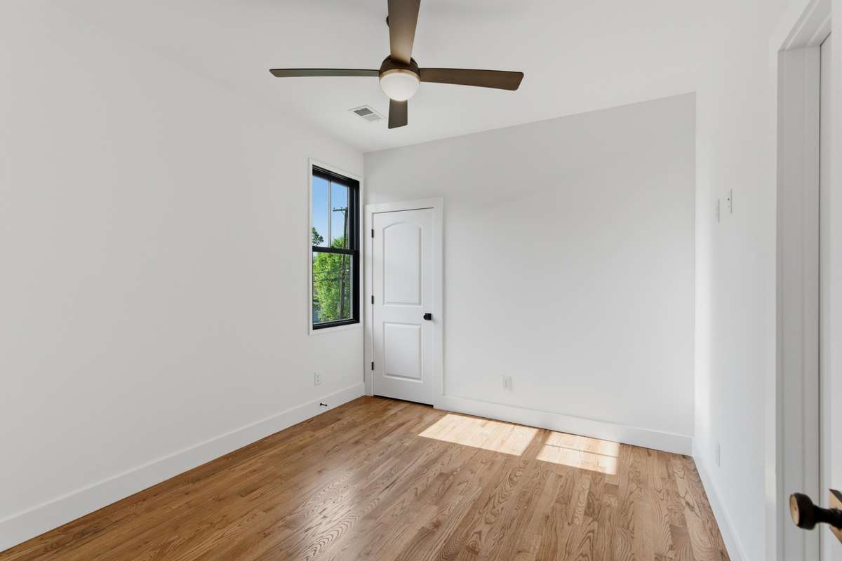 The second floor features two additional spacious bedrooms, each finished with walnut hardwoods and modern ceiling fans.