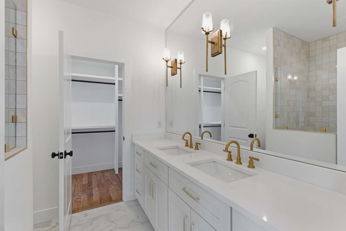 The primary bathroom offers a high-end feel with a double vanity and clean quartz countertops.