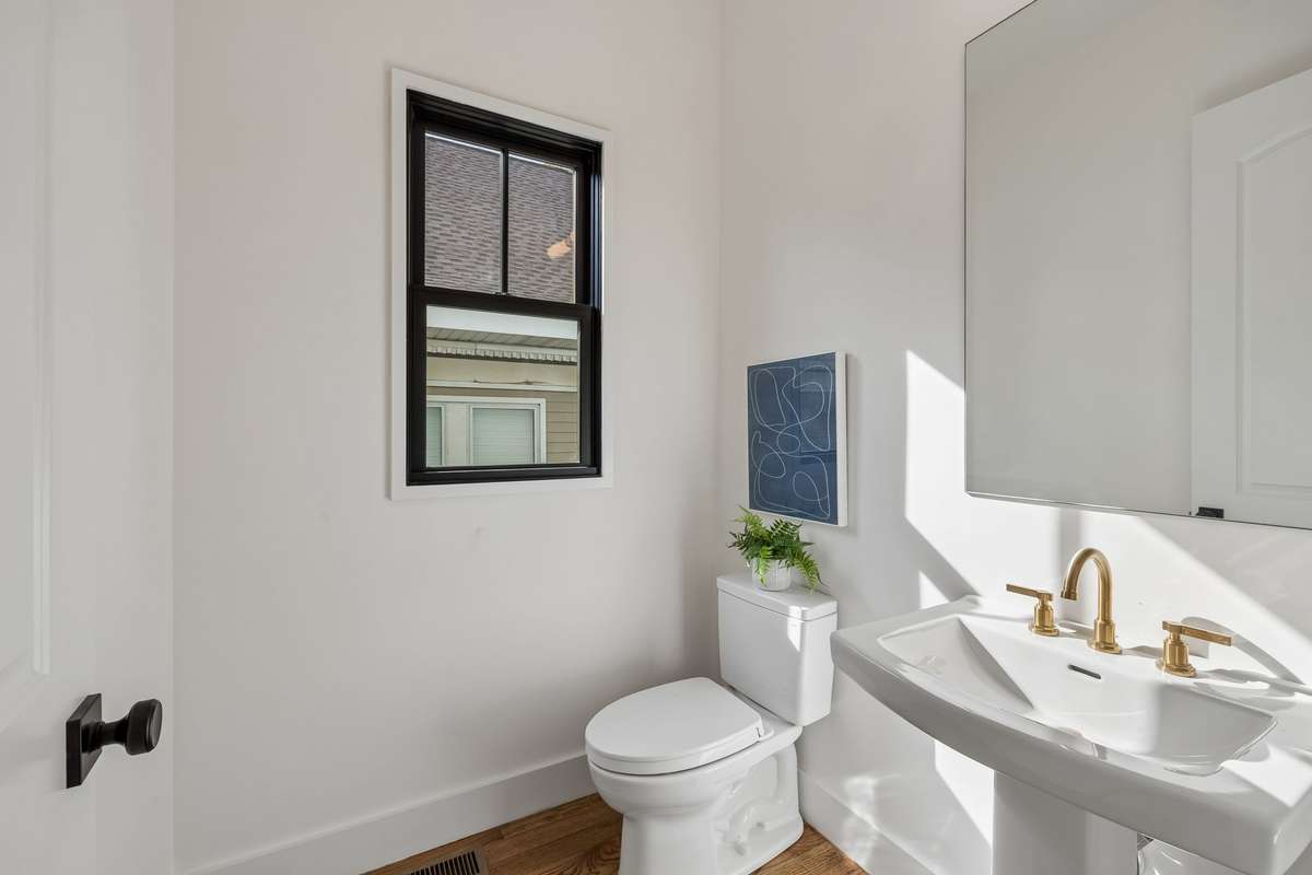 A convenient half bath is tucked nearby for guests.