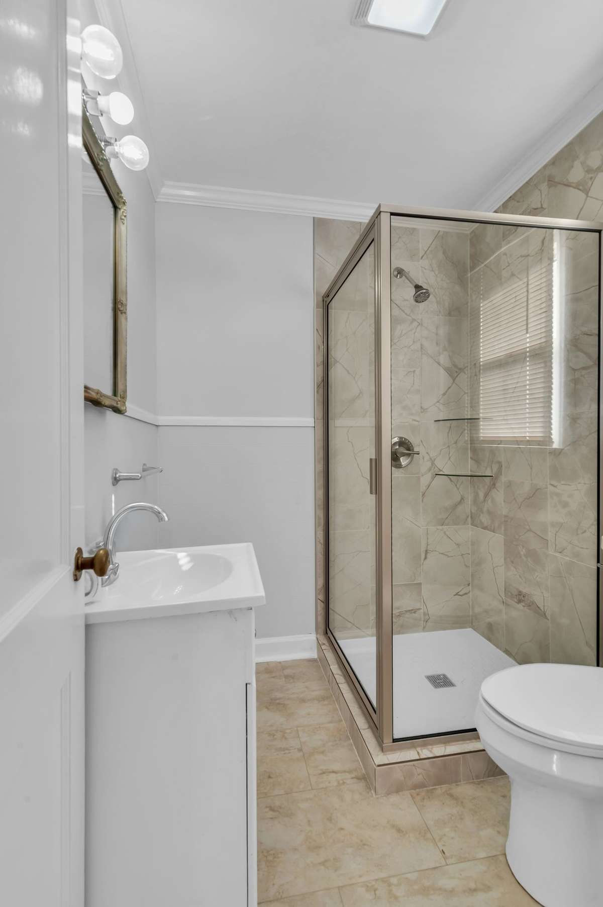 Fully remodeled bath with a window over the toilet and taller height vanity