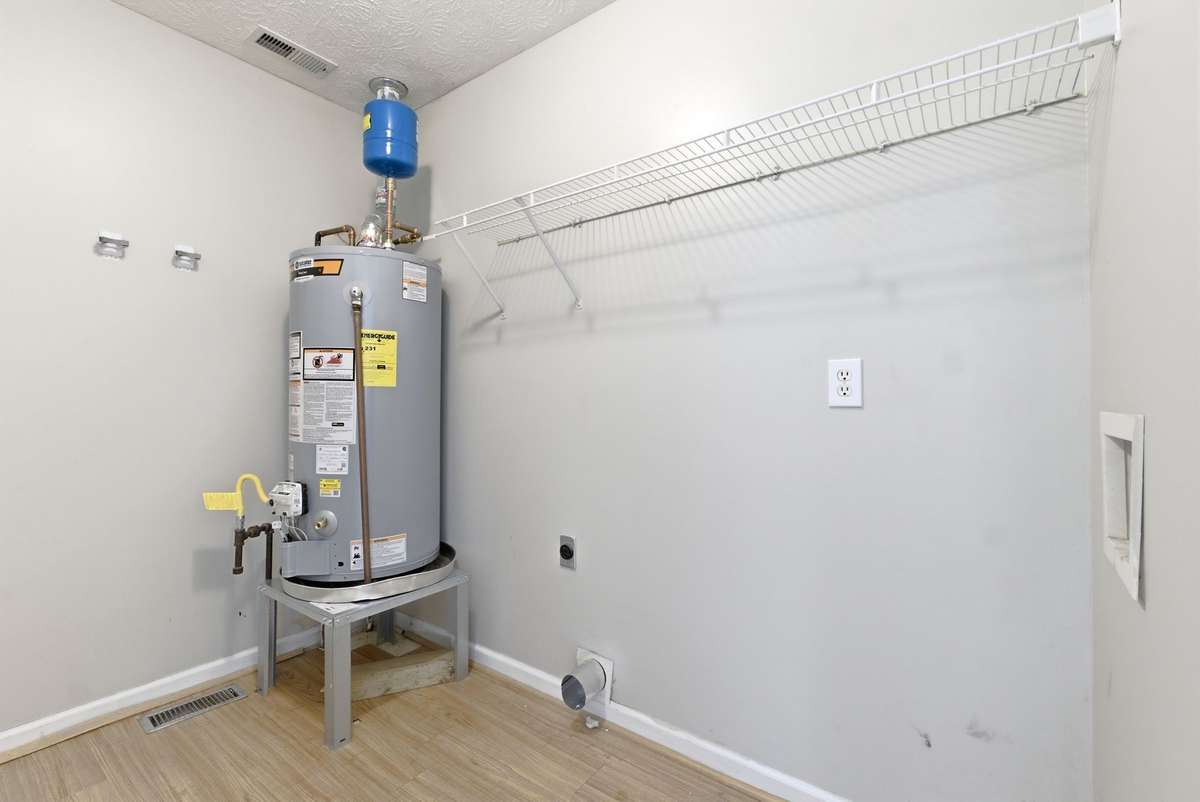 Large laundry room with washer/dryer hookups and shelving for your laundry supplies.