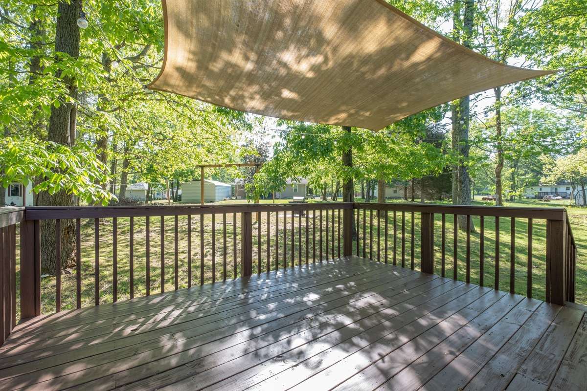 Newly painted back deck, which includes a canvas sun cover and outdoor lighting.