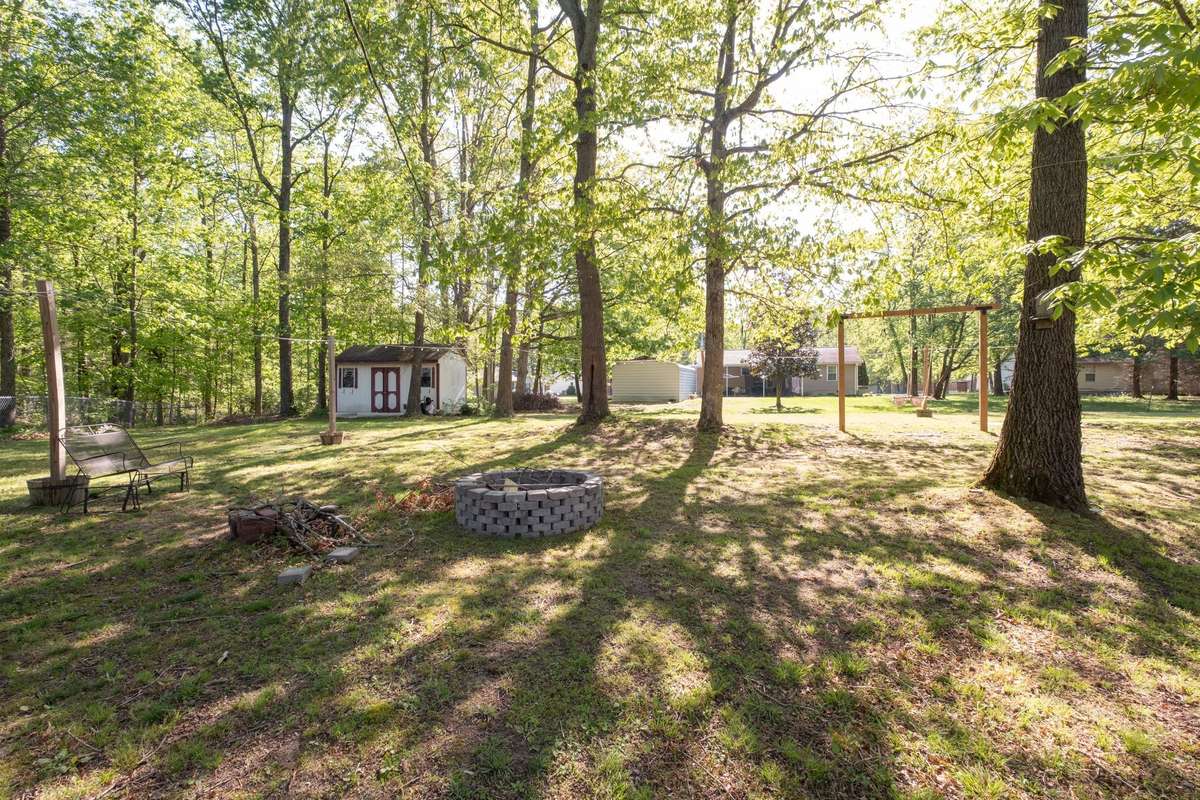 Great backyard with plenty of room to run around, a swing set, fire pit, and a storage shed that stays.