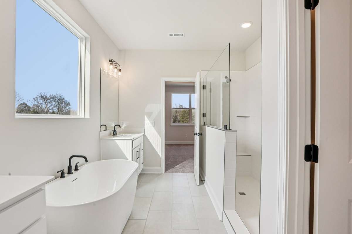 The spa-inspired Owner's Bath features separate sinks with quartz countertops and tile flooring.