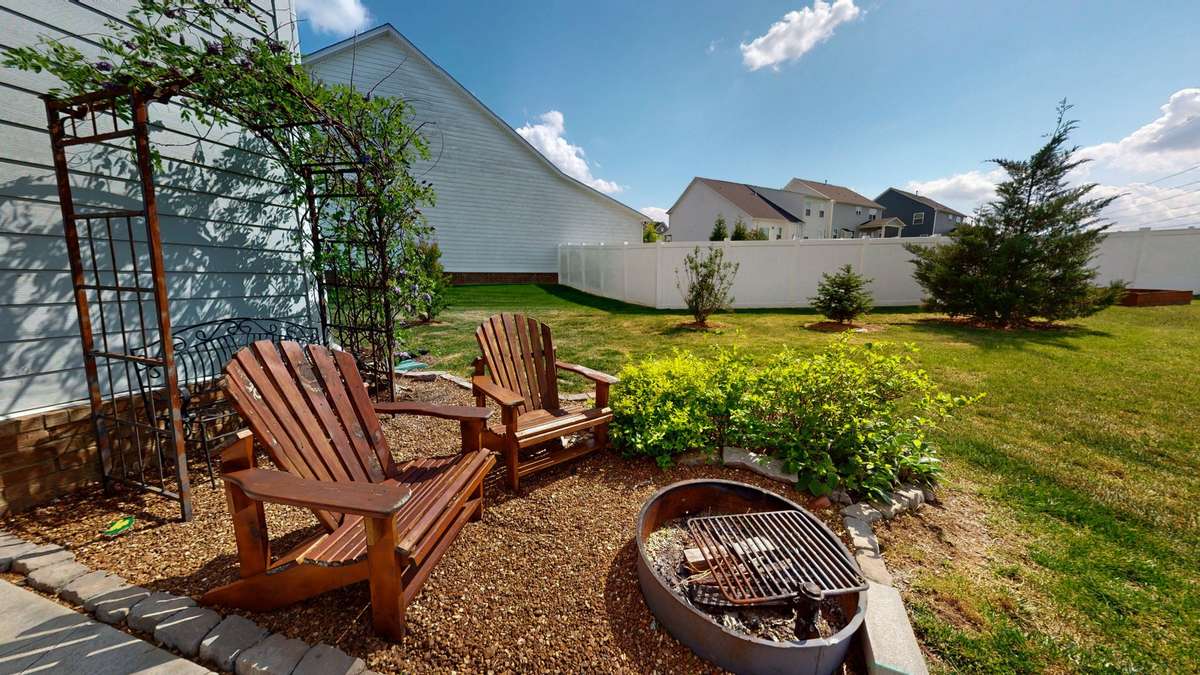 Charming garden arbor framed by a cozy firepit lounge
