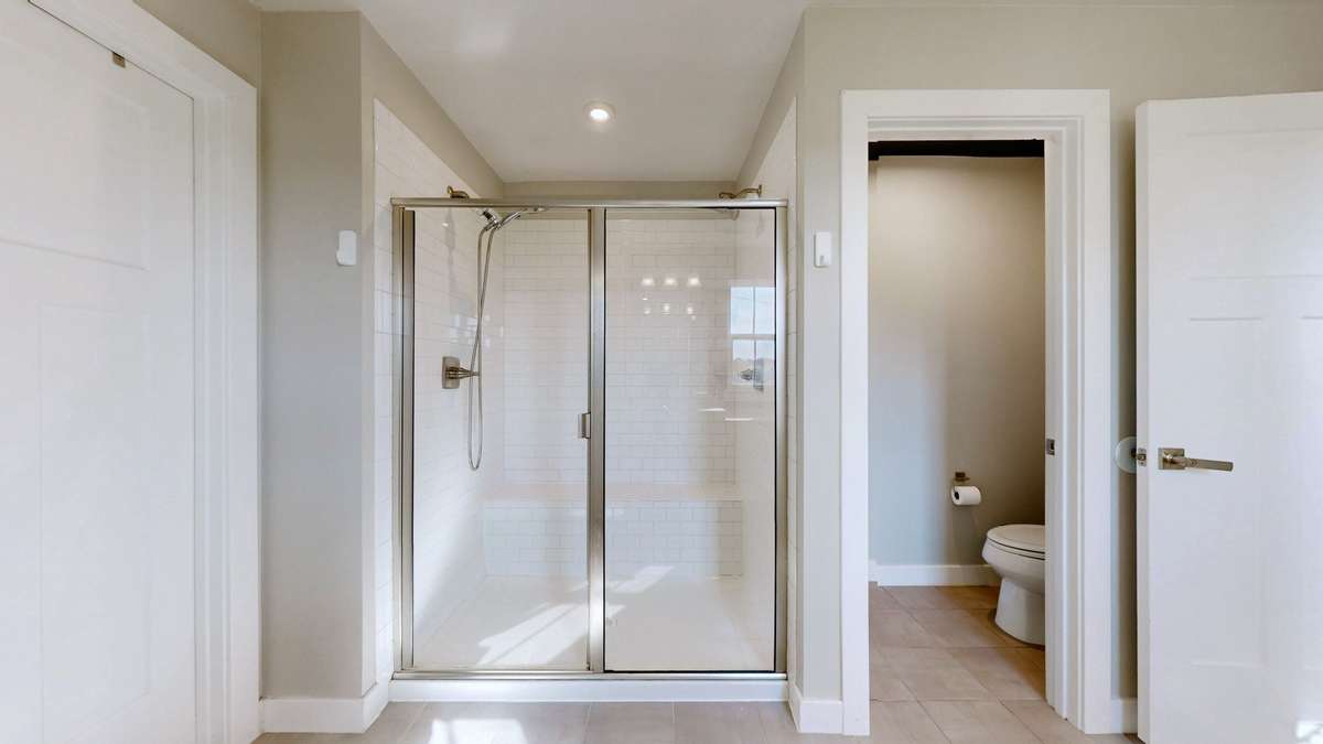 Luxurious walk in shower with dual shower heads in primary bath