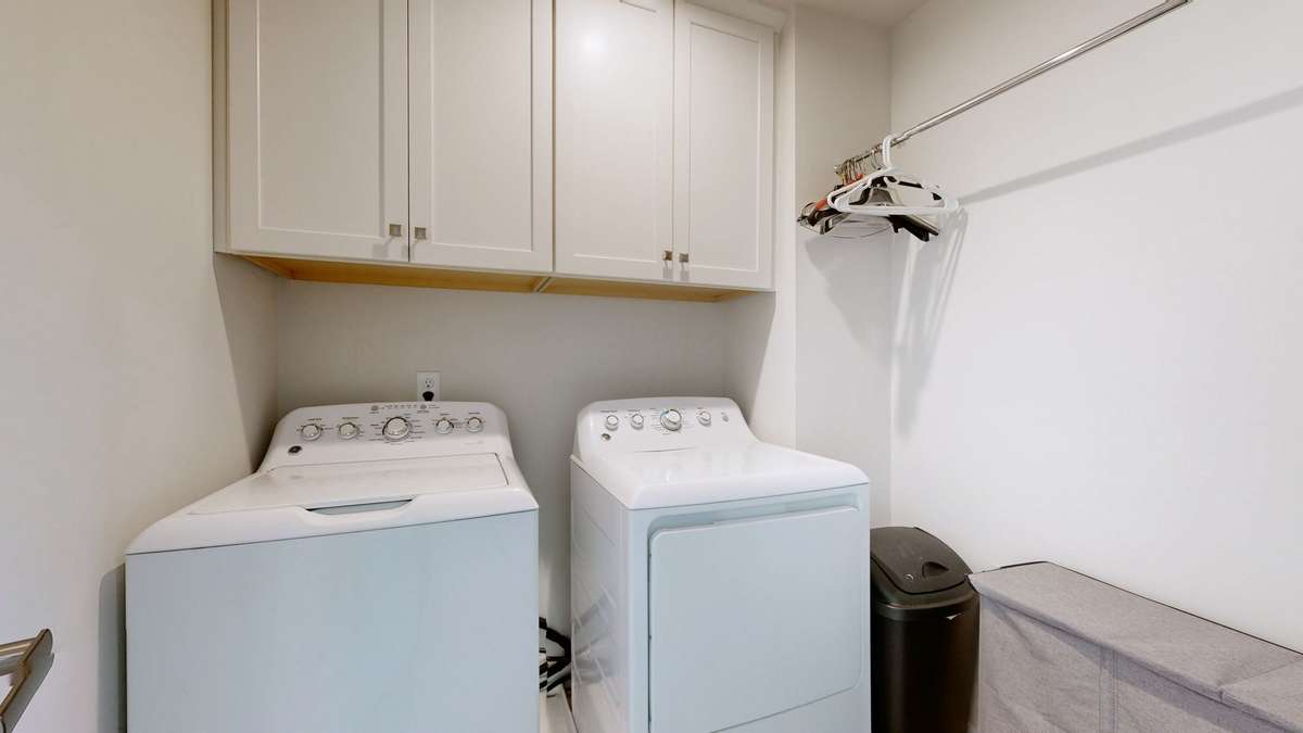 Convenient upstairs laundry room with hanging space