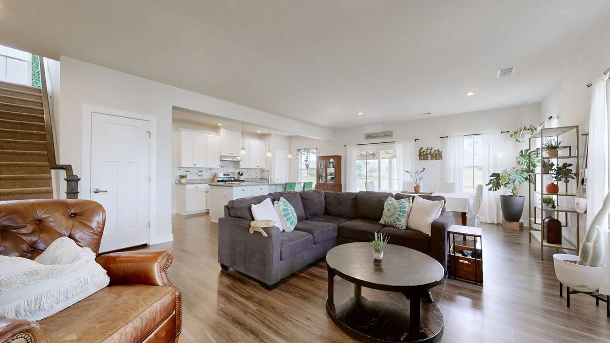 Sunlit open concept living with seamless flow between kitchen, dining & living areas