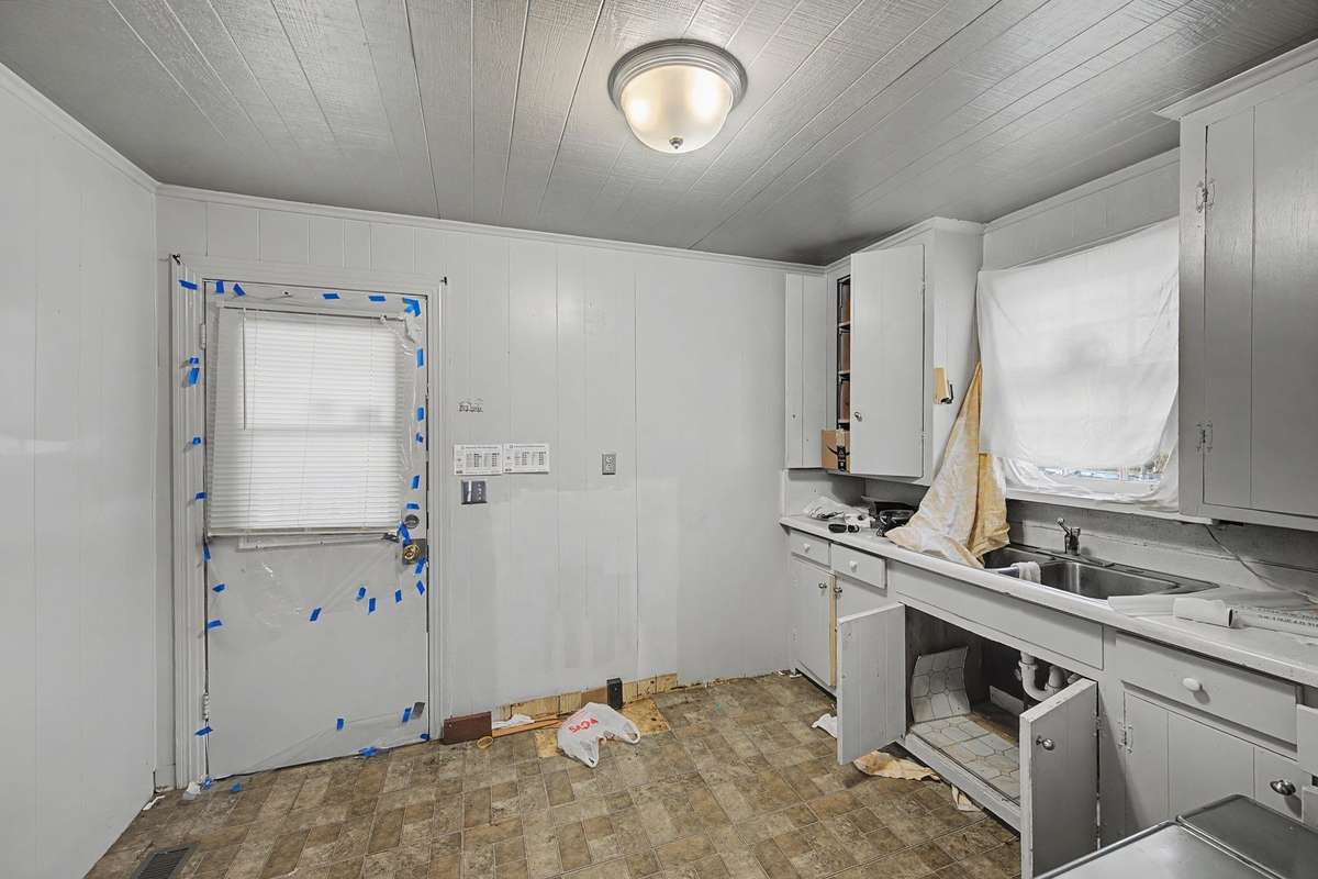 The kitchen is directly off of the living room, and currently has a side door entrance.
