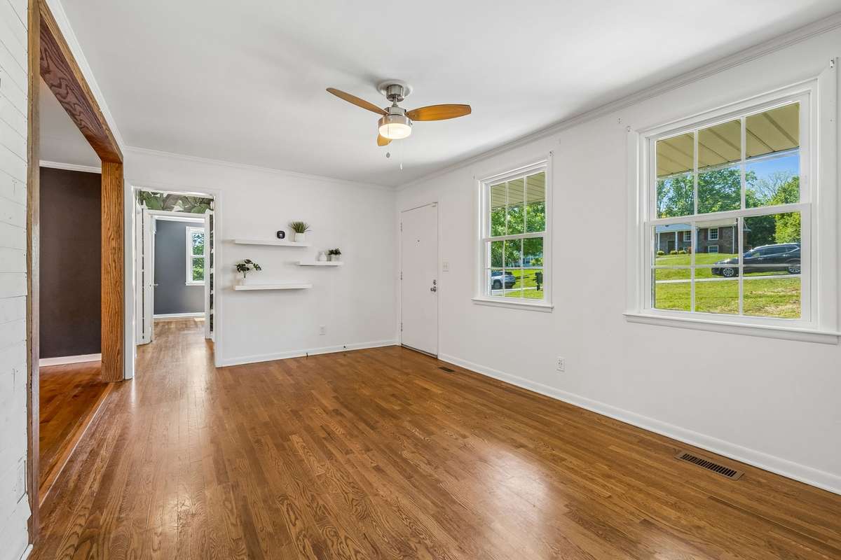 Spacious living room with abundant natural light and hardwood floors, offering plenty of room to relax or entertain.