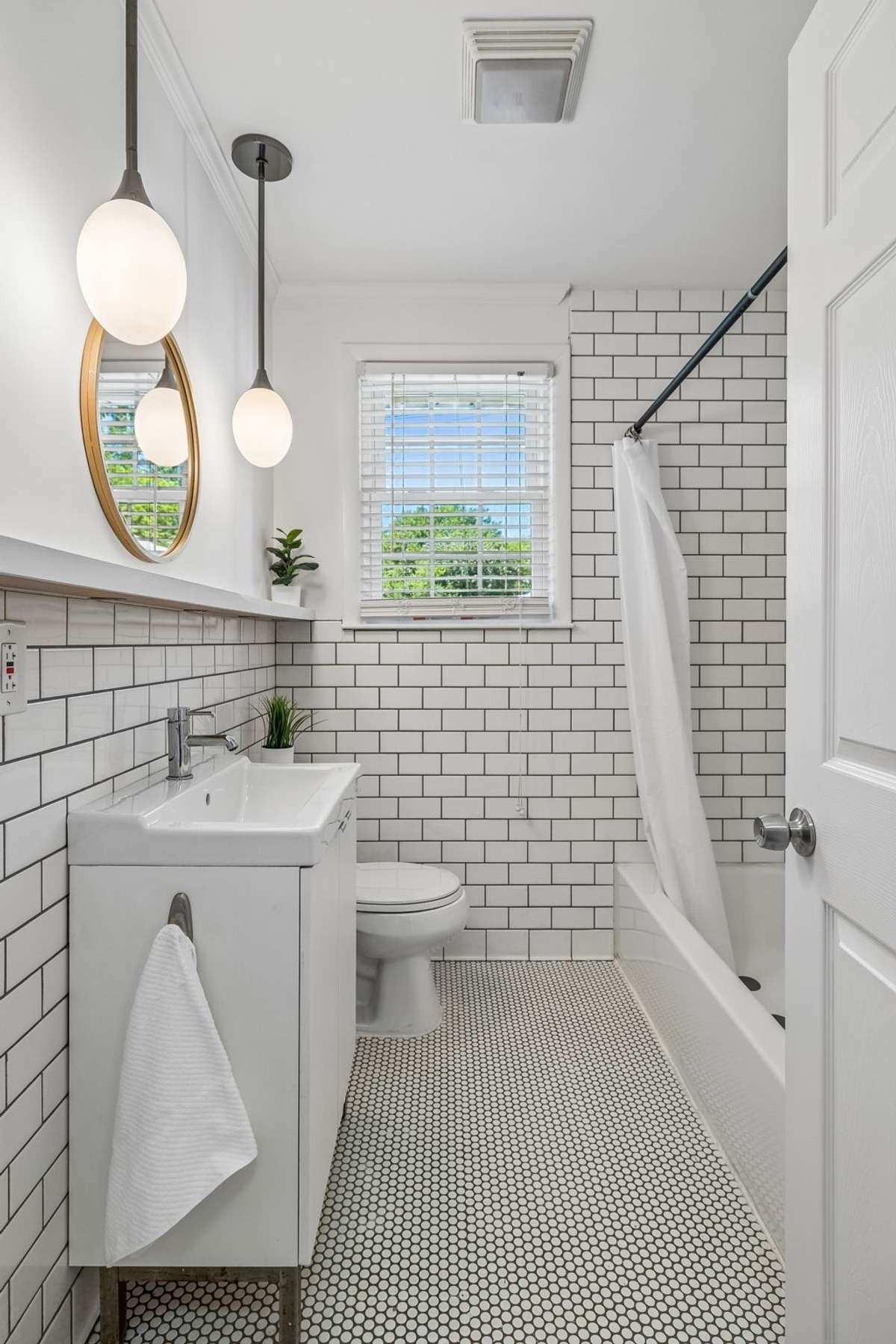 Stylishly updated main-level bathroom with classic tile, modern fixtures, and fresh, bright finishes.