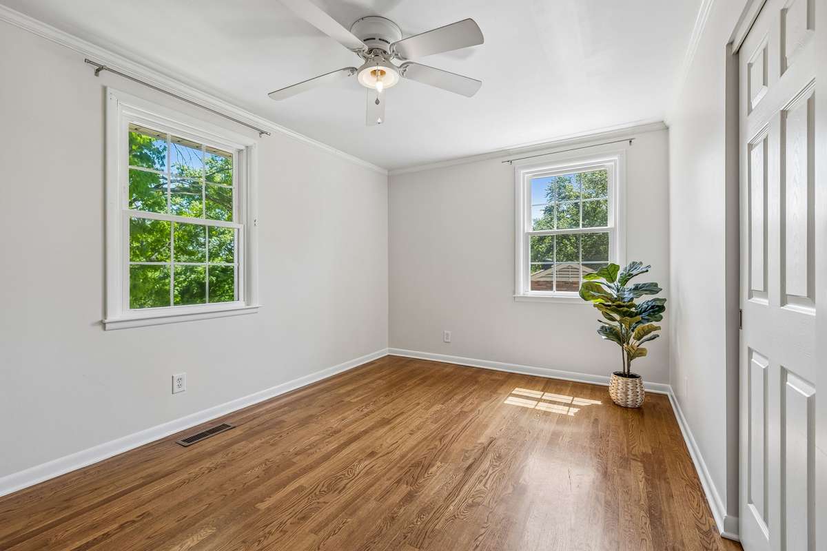 Second main-level bedroom with hardwood floors, great natural light, and a spacious closet.