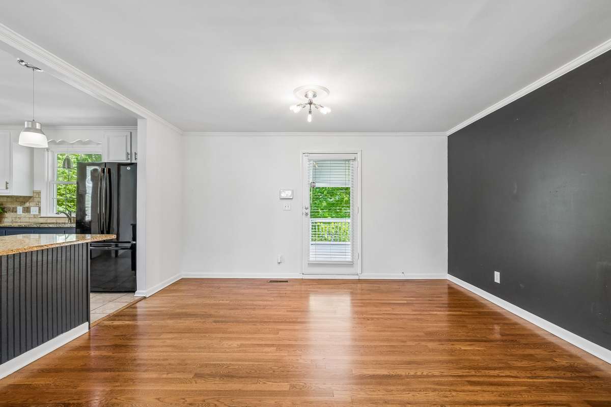 Dedicated dining room with hardwood floors, open sightlines, and direct access to the covered deck—ideal for easy entertaining.