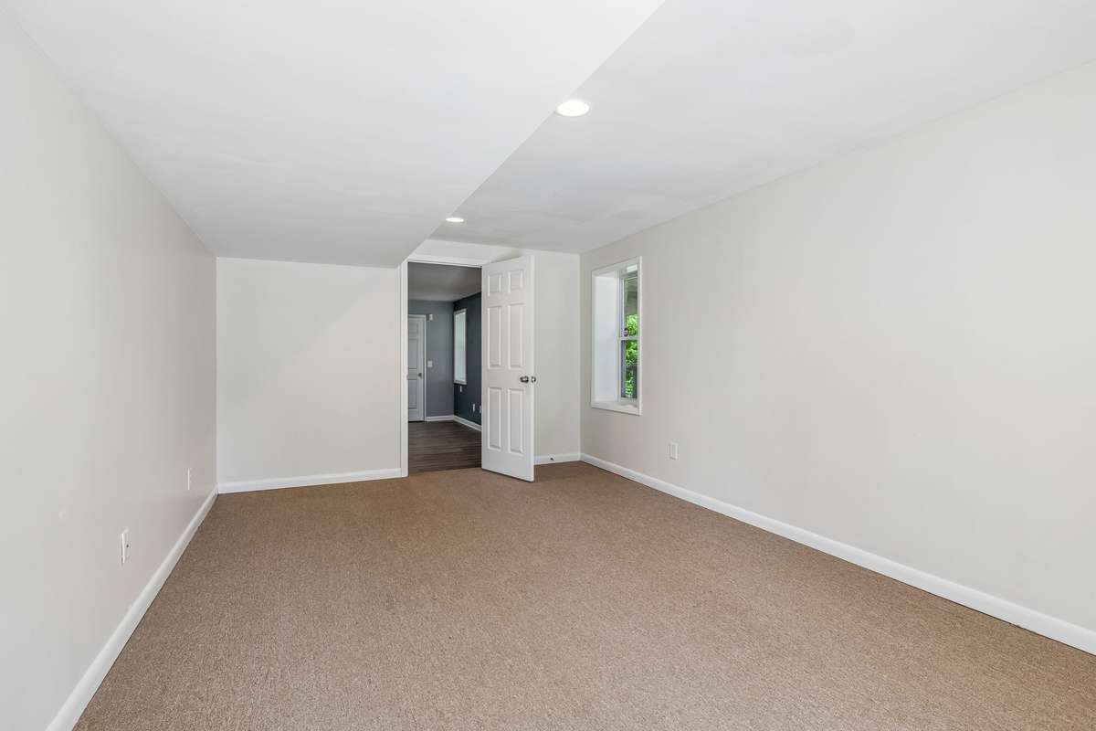 Expansive lower-level bonus room with flexible space for an office, playroom, or additional living area, plus exterior access.