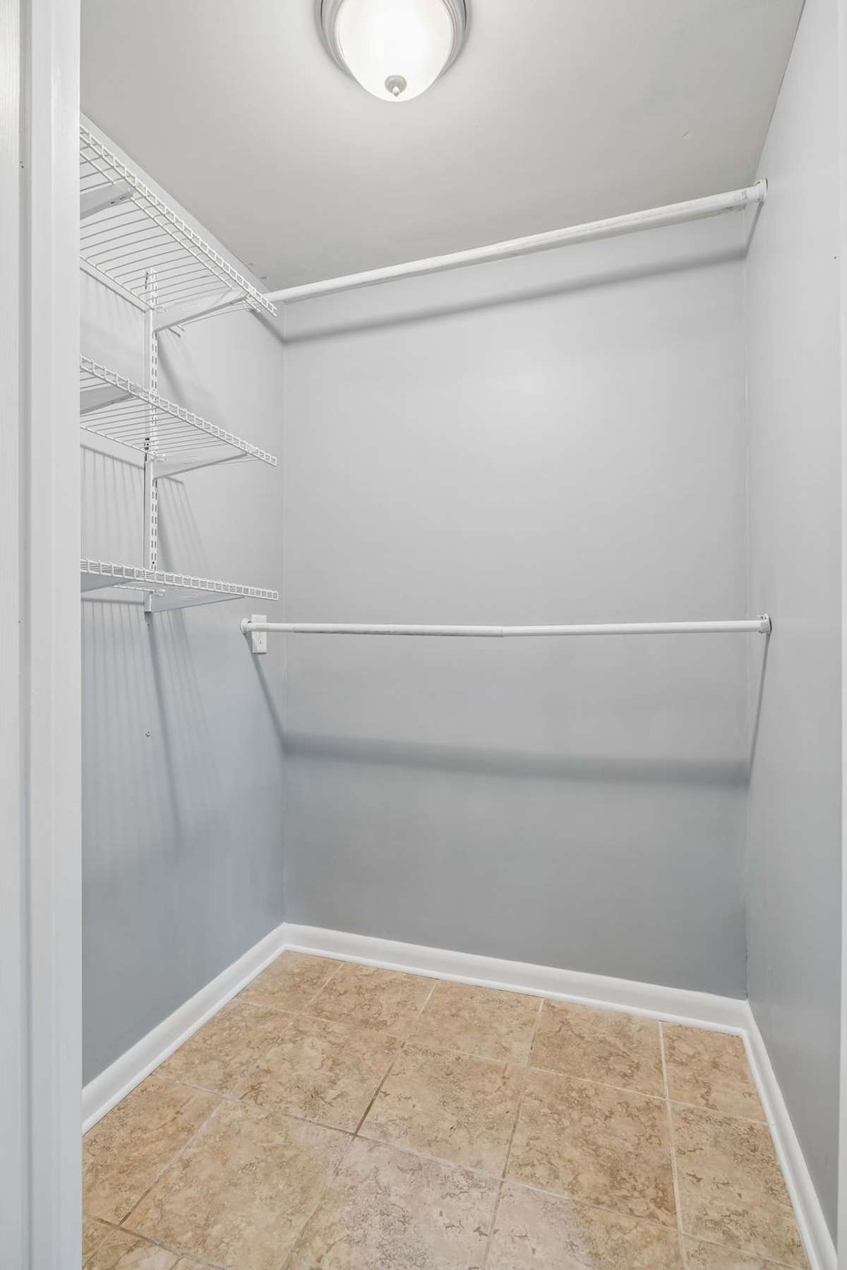 Spacious walk-in closet for the lower-level primary suite with ample shelving and storage.