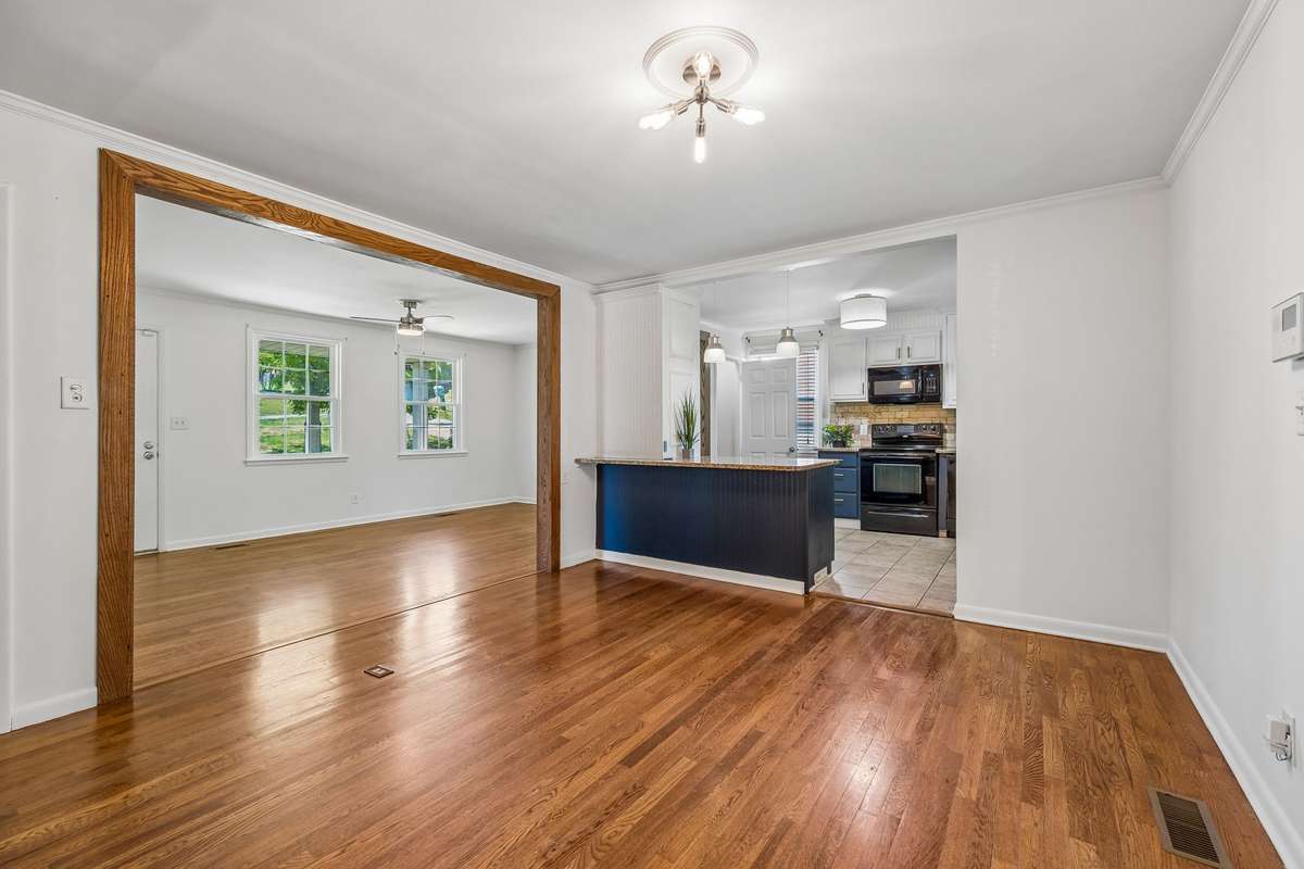 Dedicated dining room with hardwood floors, open sightlines, and direct access to the covered deck—ideal for easy entertaining.