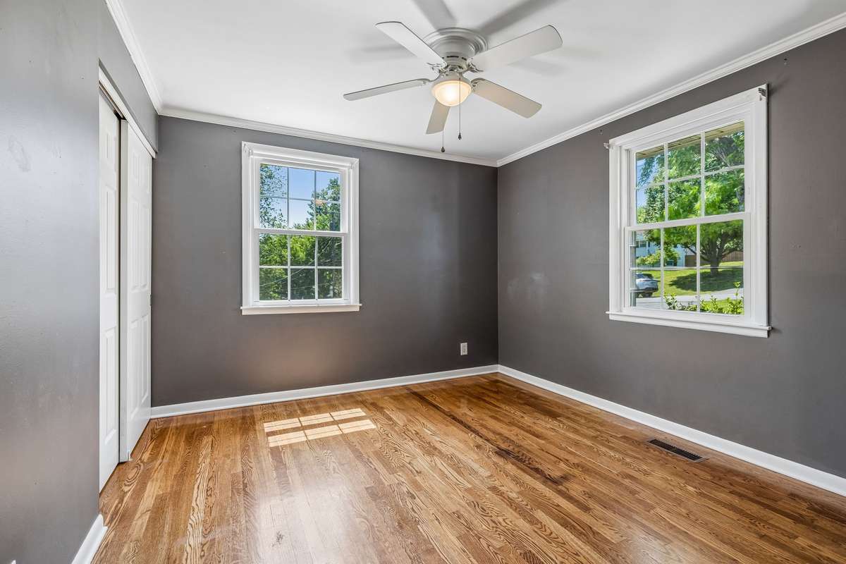 Main-level bedroom with hardwood floors, abundant natural light, and a spacious closet.