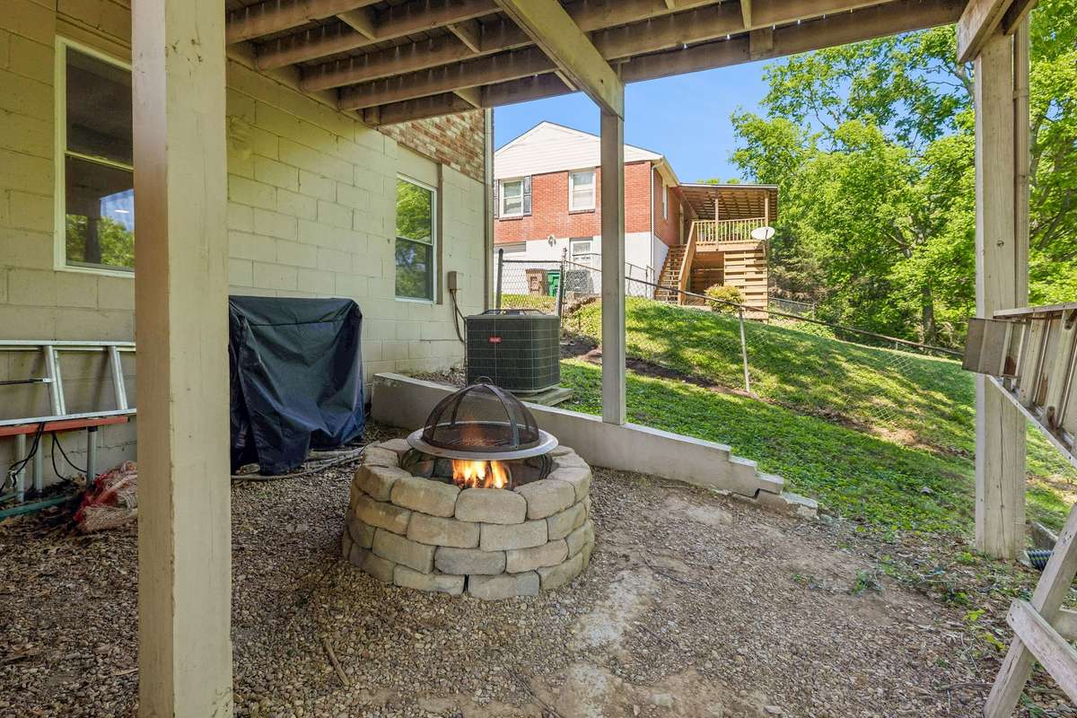Additional outdoor living space beneath the deck with a fire pit—perfect for relaxing evenings and gatherings. (virtual fire)