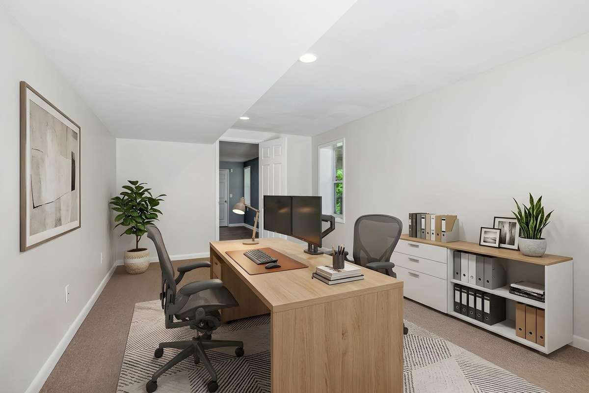 Expansive lower-level bonus room with flexible space for an office, playroom, or additional living area, plus exterior access. (virtually staged)