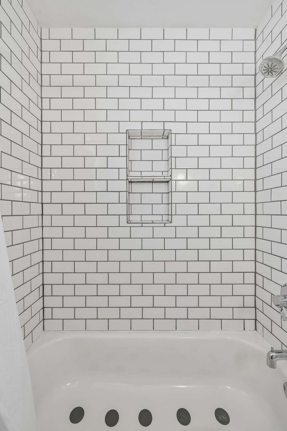Stylishly updated main-level bathroom with classic tile, modern fixtures, and fresh, bright finishes.