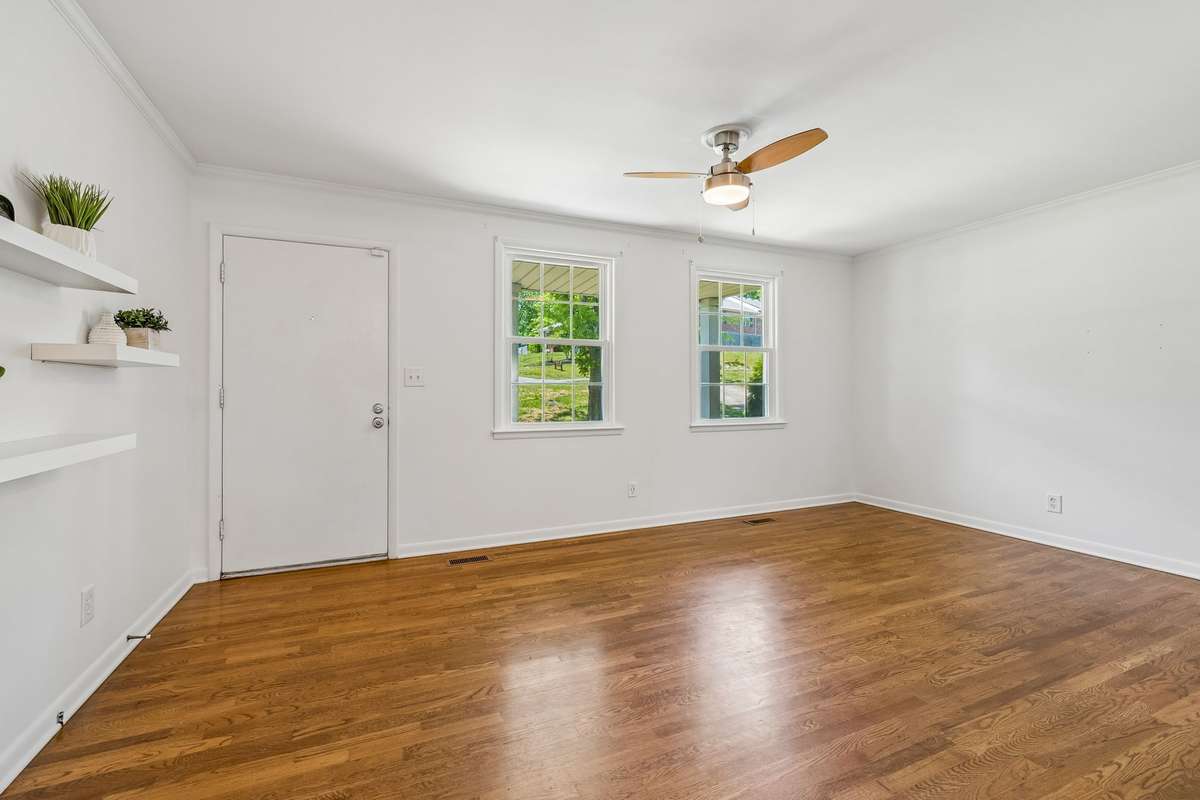 Spacious living room with abundant natural light and hardwood floors, offering plenty of room to relax or entertain.