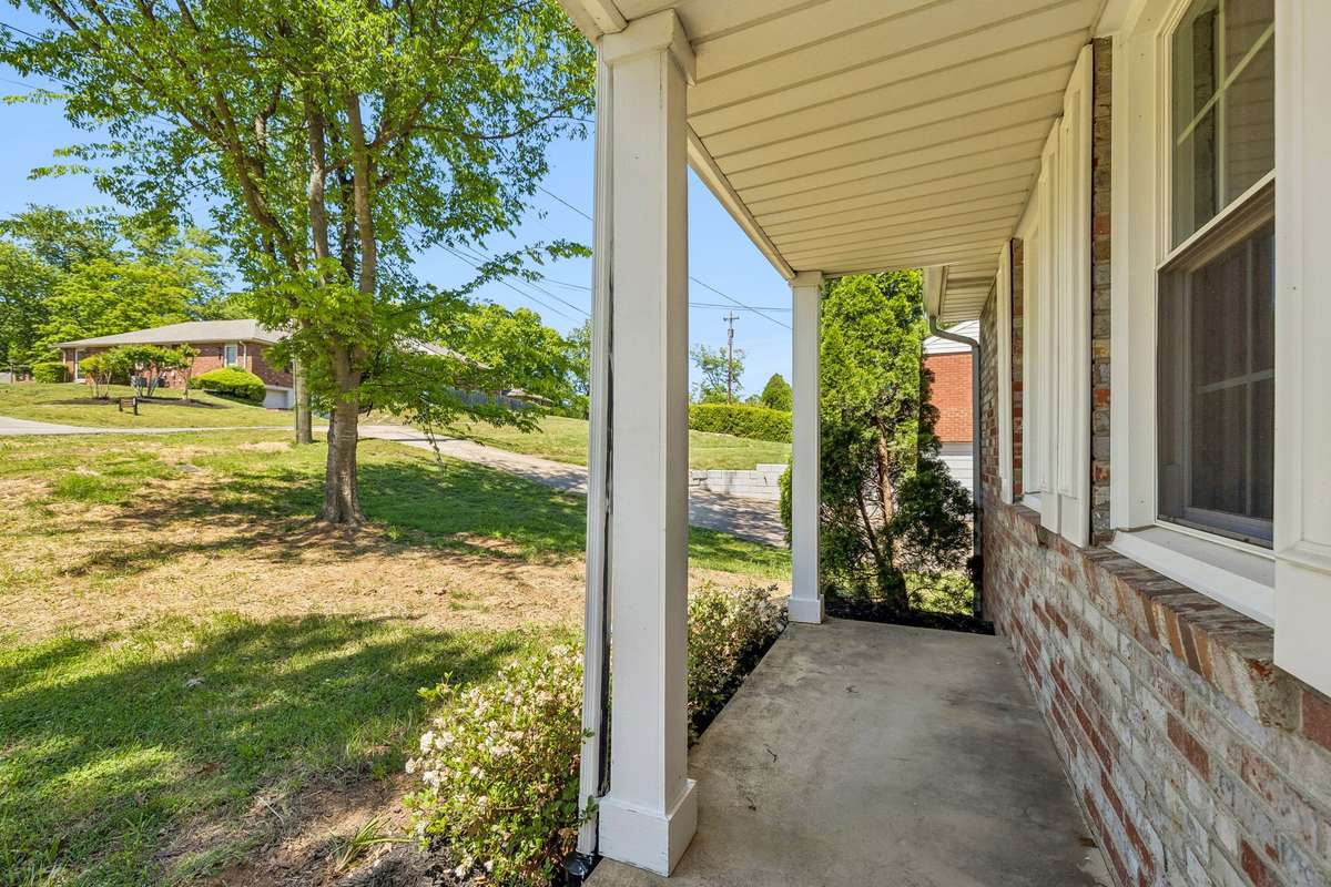 Welcoming covered front porch with charming entry—complete with a front door inspired by the iconic “Friends” design.