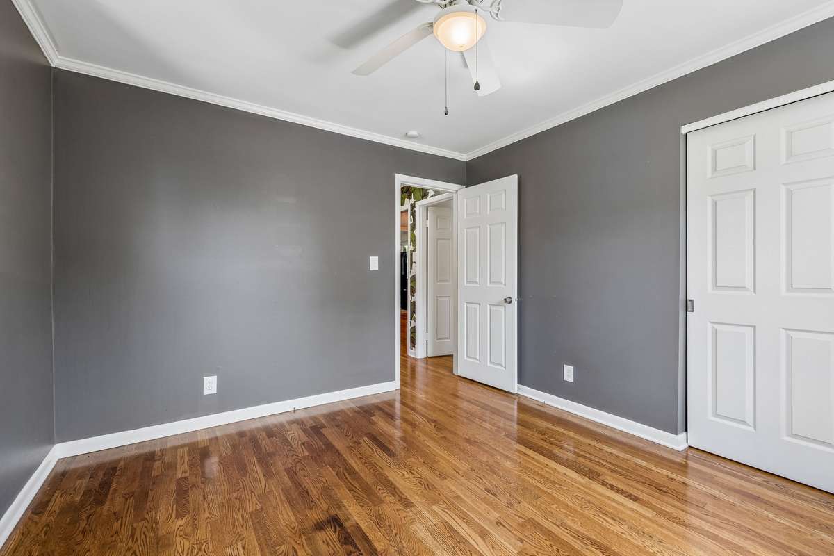 Main-level bedroom with hardwood floors, abundant natural light, and a spacious closet.