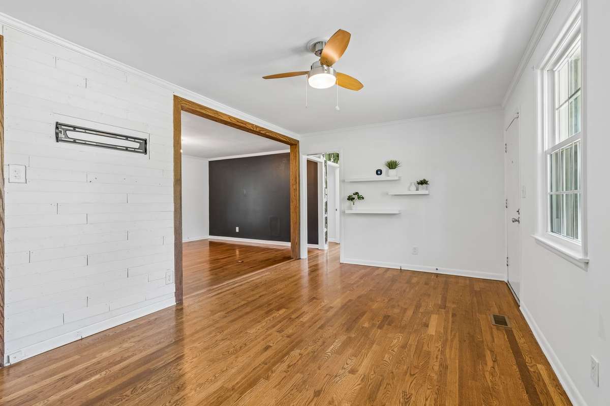 Spacious living room with abundant natural light and hardwood floors, offering plenty of room to relax or entertain.