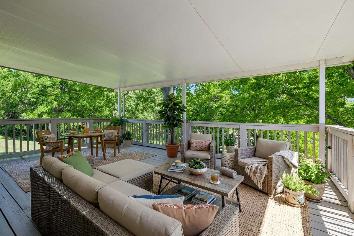 Expansive covered deck off the dining room—perfect for outdoor entertaining and enjoying the private, tree-lined setting. (virtually staged)