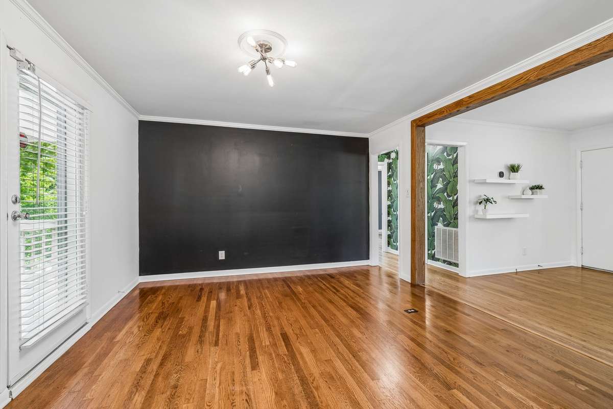 Dedicated dining room with hardwood floors, open sightlines, and direct access to the covered deck—ideal for easy entertaining.