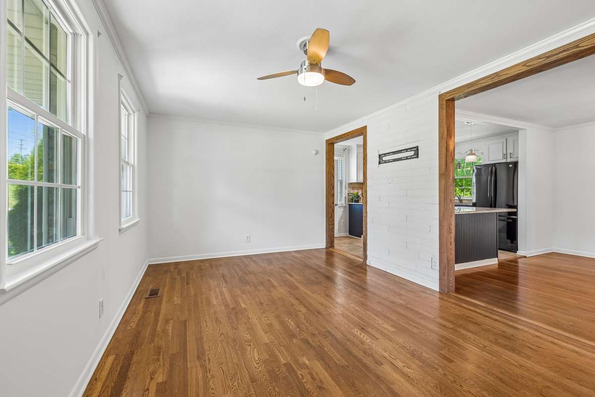 Spacious living room with abundant natural light and hardwood floors, offering plenty of room to relax or entertain.