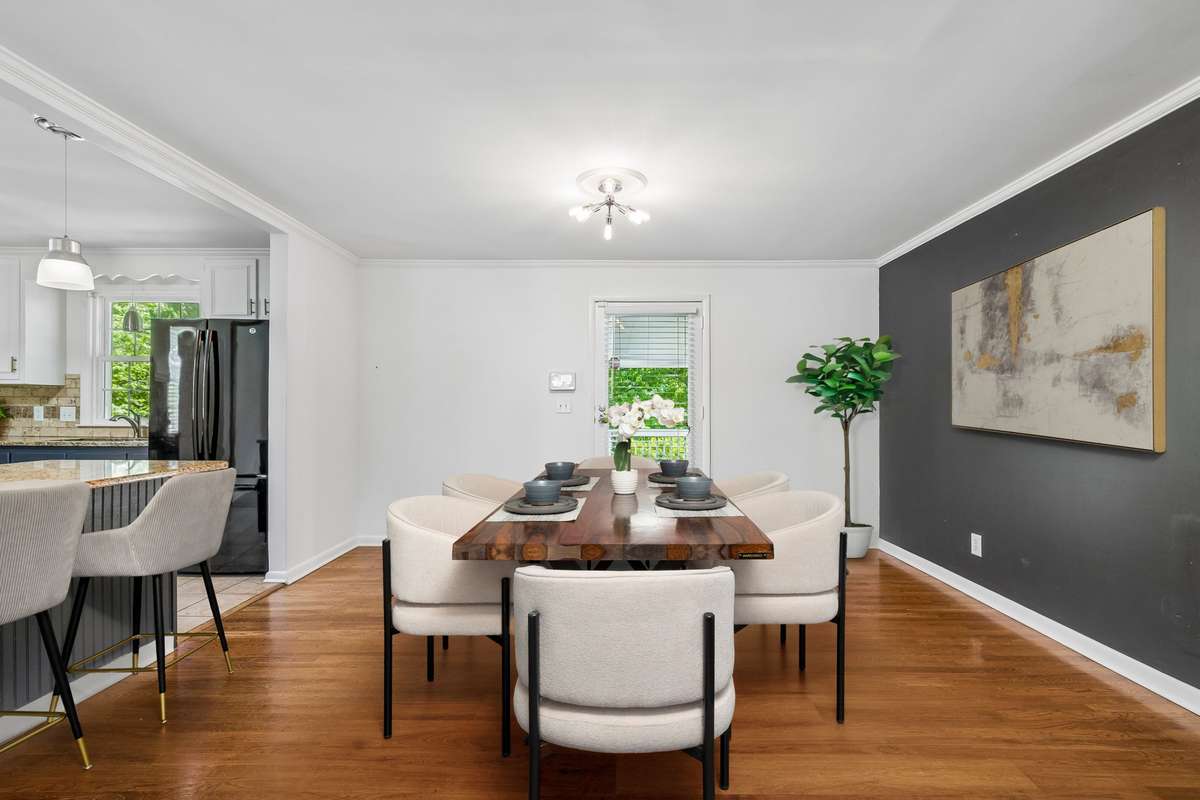 Dedicated dining room with hardwood floors, open sightlines, and direct access to the covered deck—ideal for easy entertaining.(virtually staged)