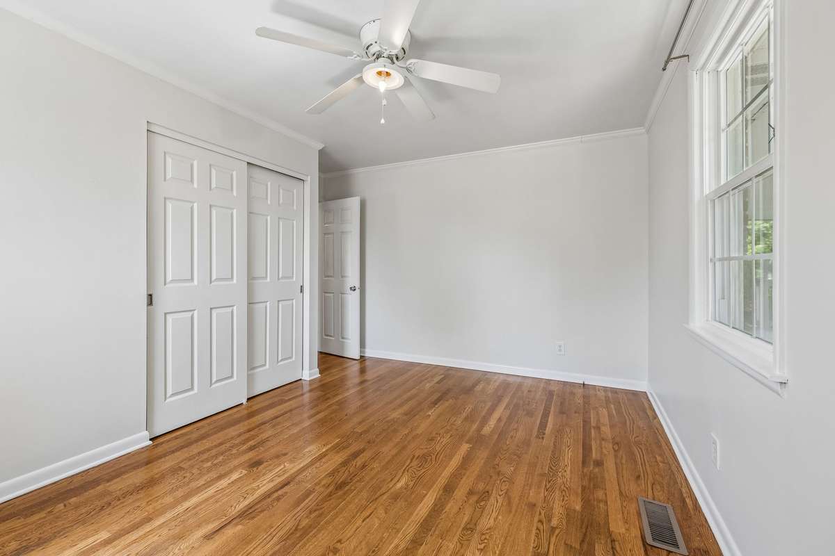 Second main-level bedroom with hardwood floors, great natural light, and a spacious closet.